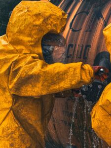 Technicians in yellow hazmat suits working to contain a barrel leak